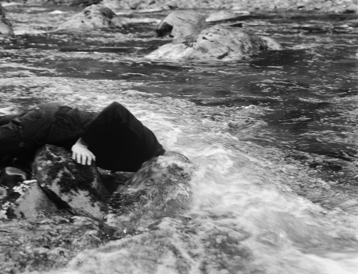Man with head in ice cold creek