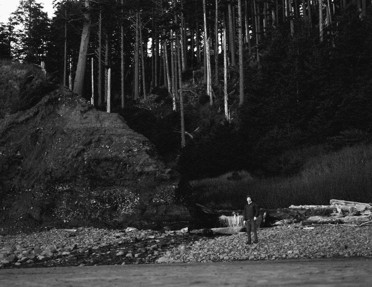 Man next to creek on beach in forest