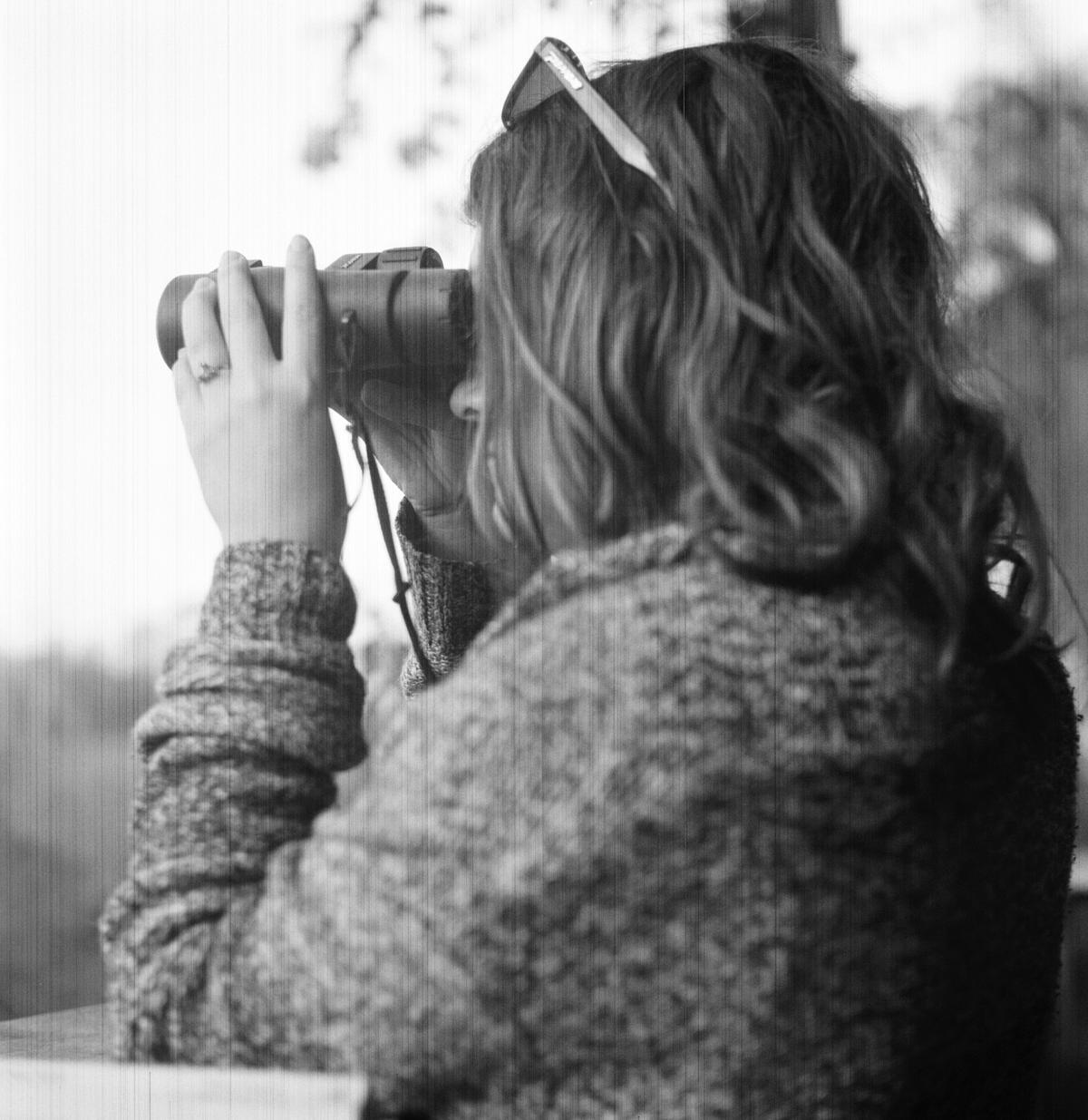 woman with binoculars bird watching in black and white
